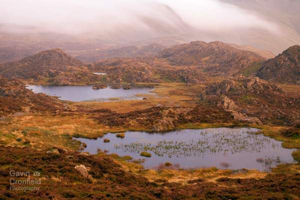 Tarns on Haystacks summit plateau during stormy red sunset