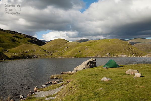 terra nova tent pitched on grassy area beside easedale tarn under fluffy clouds