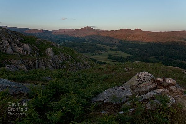 harter fell and green crag illuminated by setting sun above eskdale in summer