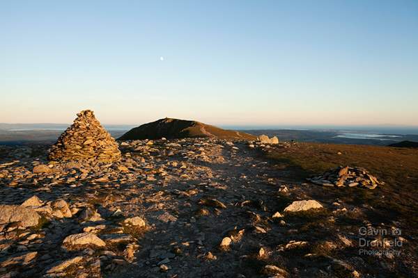 moon over coniston old man summit crag and duddon estuary from footpath over brim fell at sunset