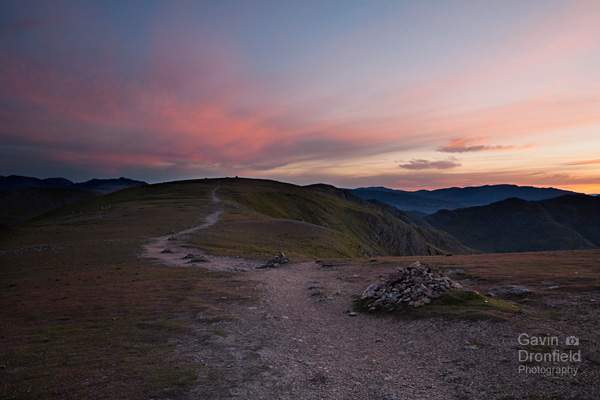 cairns lining the footpath from coniston old man to brim fell under spectacular red blue and yellow dawn sky