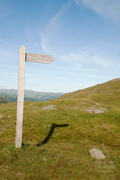 wooden fingerpost pointing to wet side edge at wrynose pass summit
