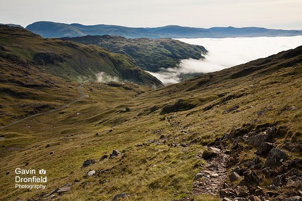 footpath from wetside edge leading down to wrynose pass with cloud inversion in little langdale beyond