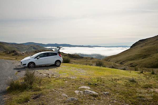 ford fiesta parked on wrynose pass with cloud inversion over windermere in distance