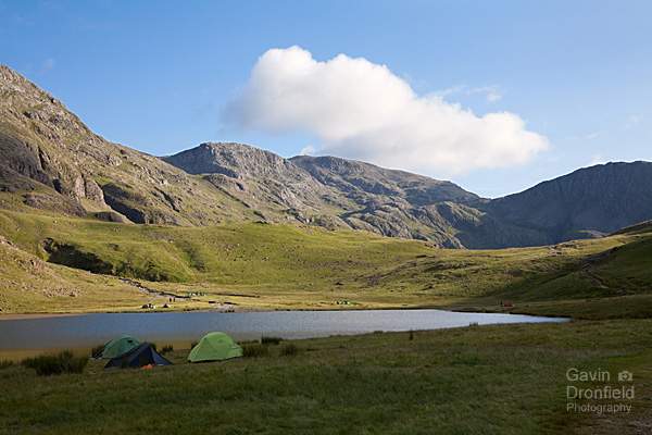 tents pitched around the shore of styhead tarn on a summer evening