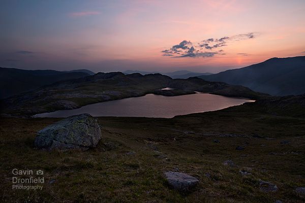 seathwaite fell and sprinkling tarn at dawn under red skies