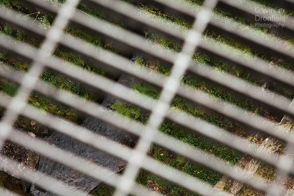 view through grill of stanley ghyll viewing platform down 150 feet to bottom of gorge