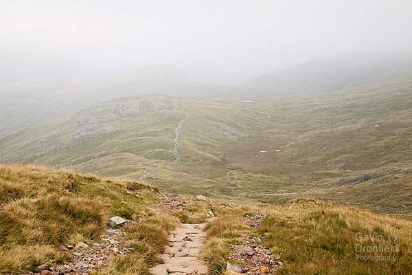 footpath over tongue head ridge in mist seen from paved path off esk hause