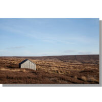 wooden shooting hut on slape wath moor on winter moorland under blue skies