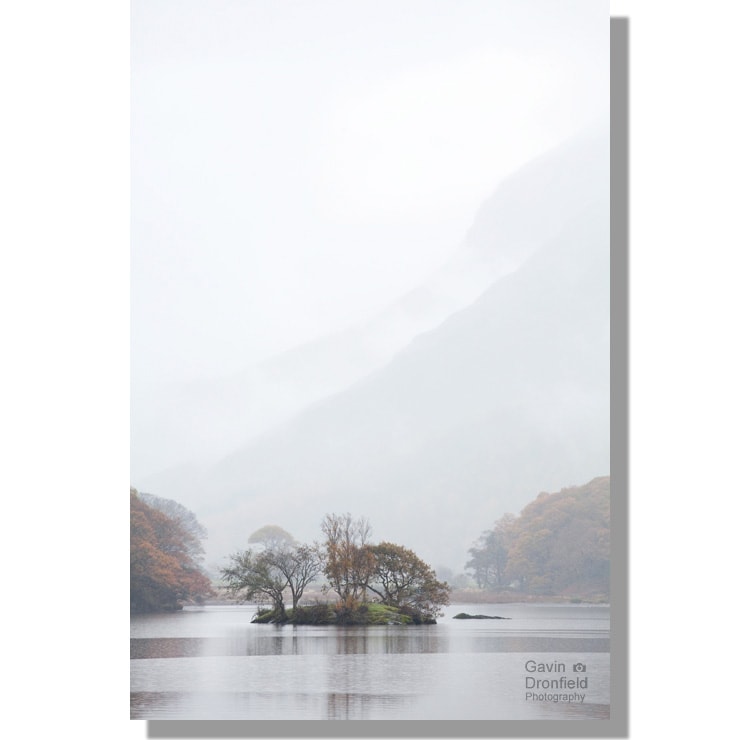 woodhouse islands reflected in crummock water under cloud enshrouded high crag ridge on grey autumn day