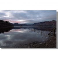 strandshag bay view of red tinged cloudy dawn over calm derwent water and catbells