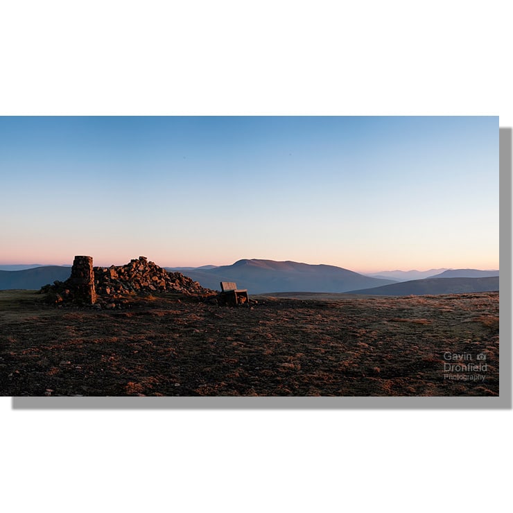 high seat summit seat trig point cairn red sunset panoramic view of bowscale fell, blencathra and scafell pike under clear blue orange sky