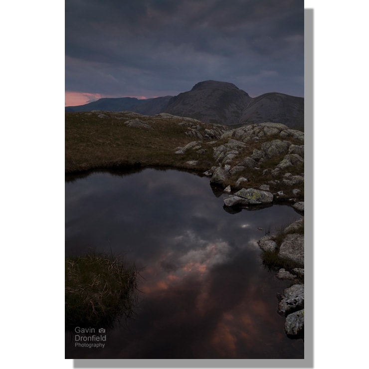 lingcomb tarns reflecting dark red sunset clouds with green gable and great gable on the skyline
