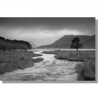 warnscale beck flowing into buttermere lake in monochrome under ominous storm clouds