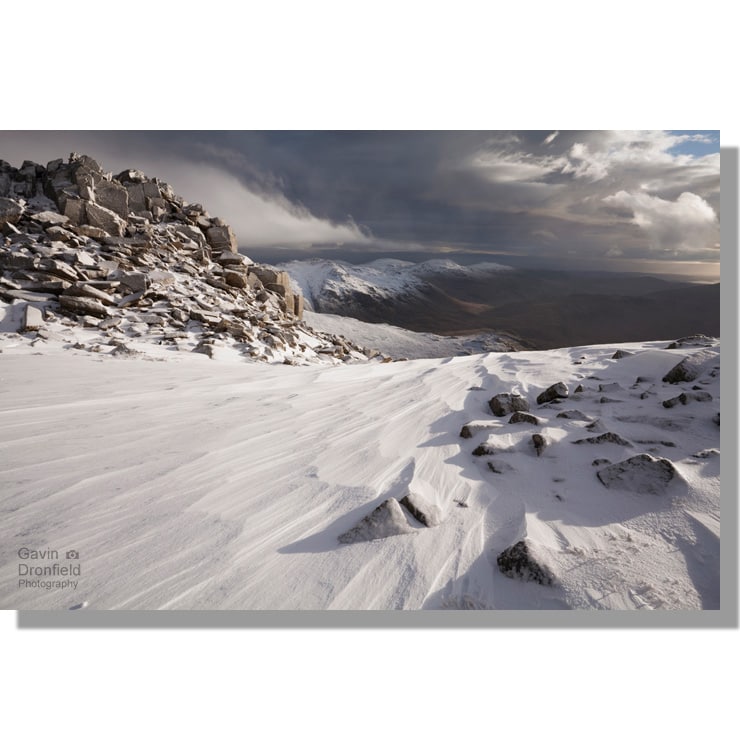 windswept snow cornice on ill crag overlooking upper eskdale under dark winter sky