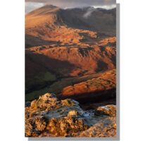 view from harter fell summit over upper eskdale and hardknott fort towards sca fell and scafell pike under low winter sun