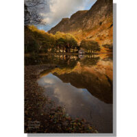 wast water boathouse and reflections catching the last golden light of day at sunset in autumn under crags of whin rigg