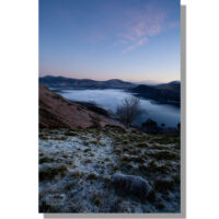 cloud inversion over derwent water before dawn from frost covered hause gate pass looking towards blencathra and skiddaw under red clouds in blue sky